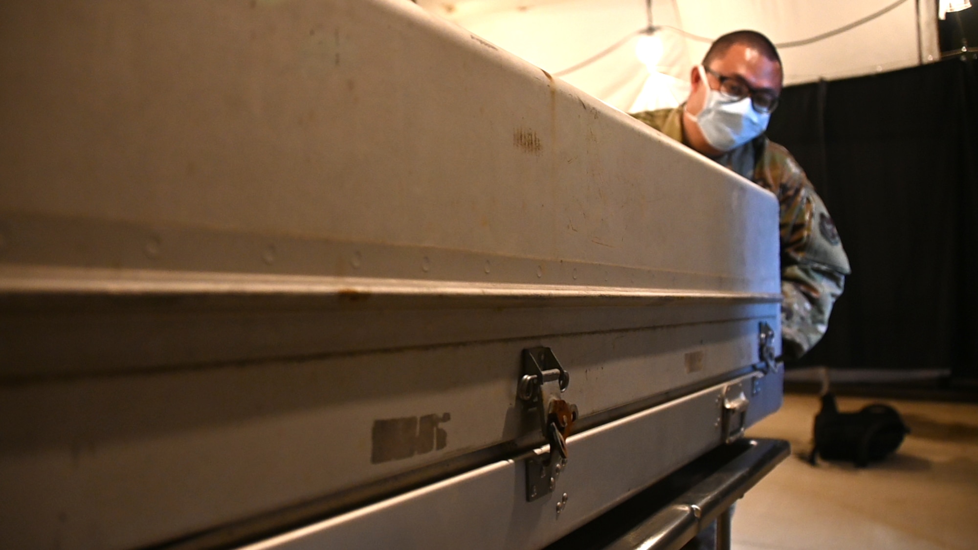 Photo of Airman moving a metal coffin.