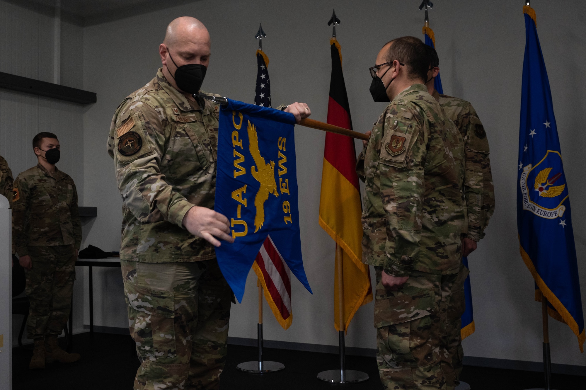 An Airman unfolds the new flag for the squadron.
