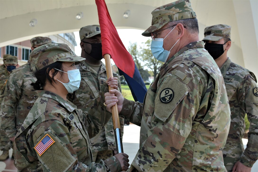 Col. Cliffton Cornell, 94th Training Division-Force Sustainment Chief of Staff (right), passes the unit guidon to Capt. Theang Sterns, incoming commander (left). Sterns assumed command of the the 94th TD-FS Headquarters and Headquarters Company during the unit's change of command ceremony. The ceremony was held at Fort Lee's Combined Arms Support Command Headquarters to bid farewell to Capt. Alex Singh and welcomed Sterns as the 94th TD-FS HHC commander on April 9, 2021. (Photo by Maj. Ebony Gay, 94th TD-FS Public Affairs Office)