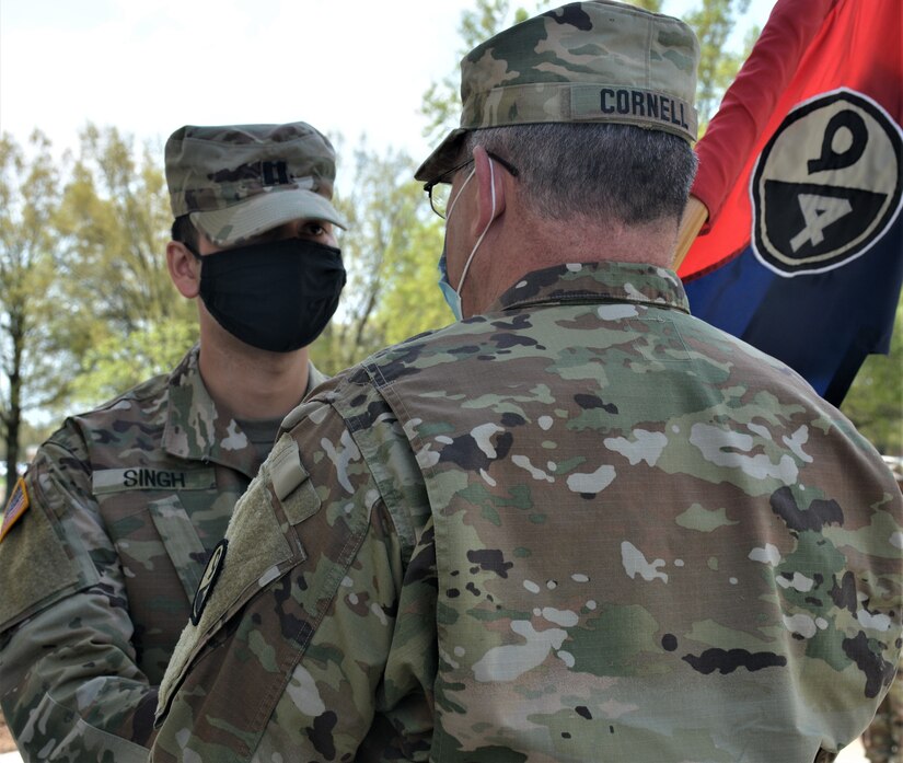 Capt. Alex Singh, outgoing commander (left), passes the unit guidon to Col. Cliffton Cornell, 94th Training Division-Force Sustainment Chief of Staff (right). Singh relinquished his command during the 94th TD-FS Headquarters and Headquarters Company change of command ceremony. The ceremony was held at Fort Lee's Combined Arms Support Command Headquarters to bid farewell to Singh and welcome Capt. Theang Sterns as the 94th TD-FS HHC commander on April 9, 2021. (Photo by Maj. Ebony Gay, 94th TD-FS Public Affairs Office)