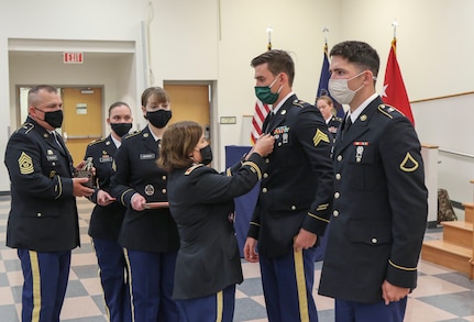 Col. Laura McHugh, deputy adjutant general-Army, Pennsylvania National Guard, presents Sgt. James McGill of the Maryland Army National Guard with an Army Commendation Medal at the conclusion of the Region II Best Warrior Competition May 14, 2021, at Fort Indiantown Gap. Eleven enlisted National Guard Soldiers from Pennsylvania, Maryland, Virginia, West Virginia, Washington D.C. and Delaware competed in the 2021 regional Best Warrior Competition at Fort Indiantown Gap May 11-14. Pfc. Alexander Gravely, a combat medic with 1st Battalion, 201st Field Artillery Regiment, 77th Brigade Troop Command, West Virginia Army National Guard, won the best Soldier portion of the competition. McGill, a radiology specialist with the 224th Medical Company Area Support, Maryland Army National Guard, won the best noncommissioned officer portion of the Best Warrior Competition.  (U.S. Army National Guard photo by Staff Sgt. Zane Craig)