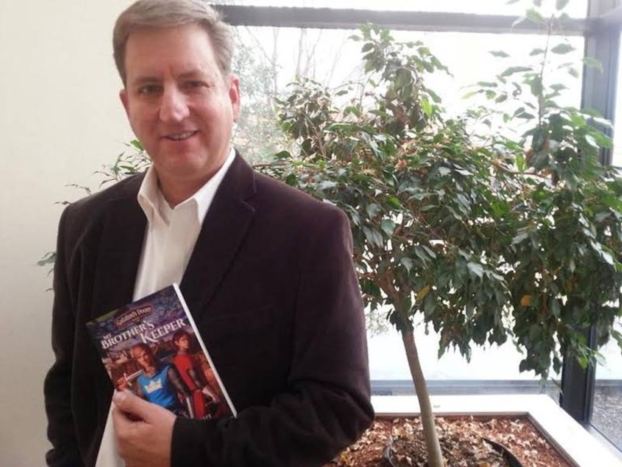 David Wright, videographer for Arnold Engineering Development Complex, pictured in October 2018 with his first book “My Brother’s Keeper,” which was published in 2014. The book is part of a series called Galahad’s Doom. The second book in the series, “Marching as to War,” came out in 2018. Wright is currently working on the third and final book, which will be called “The Armor of God.” (Courtesy photo)