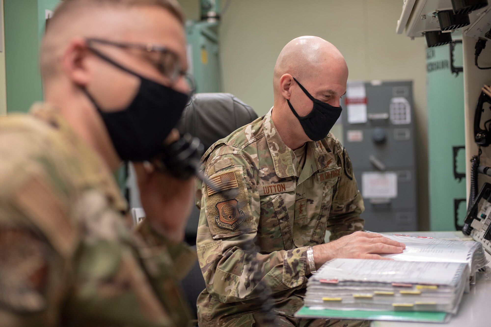 Maj. Gen. Michael J. Lutton, 20th Air Force commander, looks through launch procedures inside of the missile procedure trainer next to Capt. Mitchell Baugh, intercontinental ballistic missile combat crew commander May 12, 2021, during his trip to Malmstrom Air Force Base, Mont.