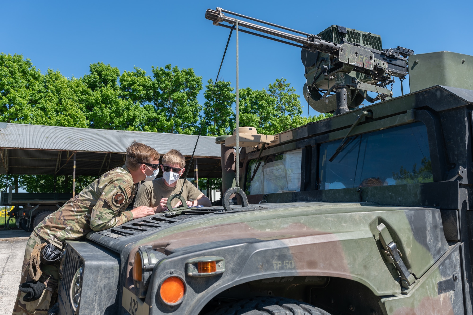 Airmen standing next to Humvee.