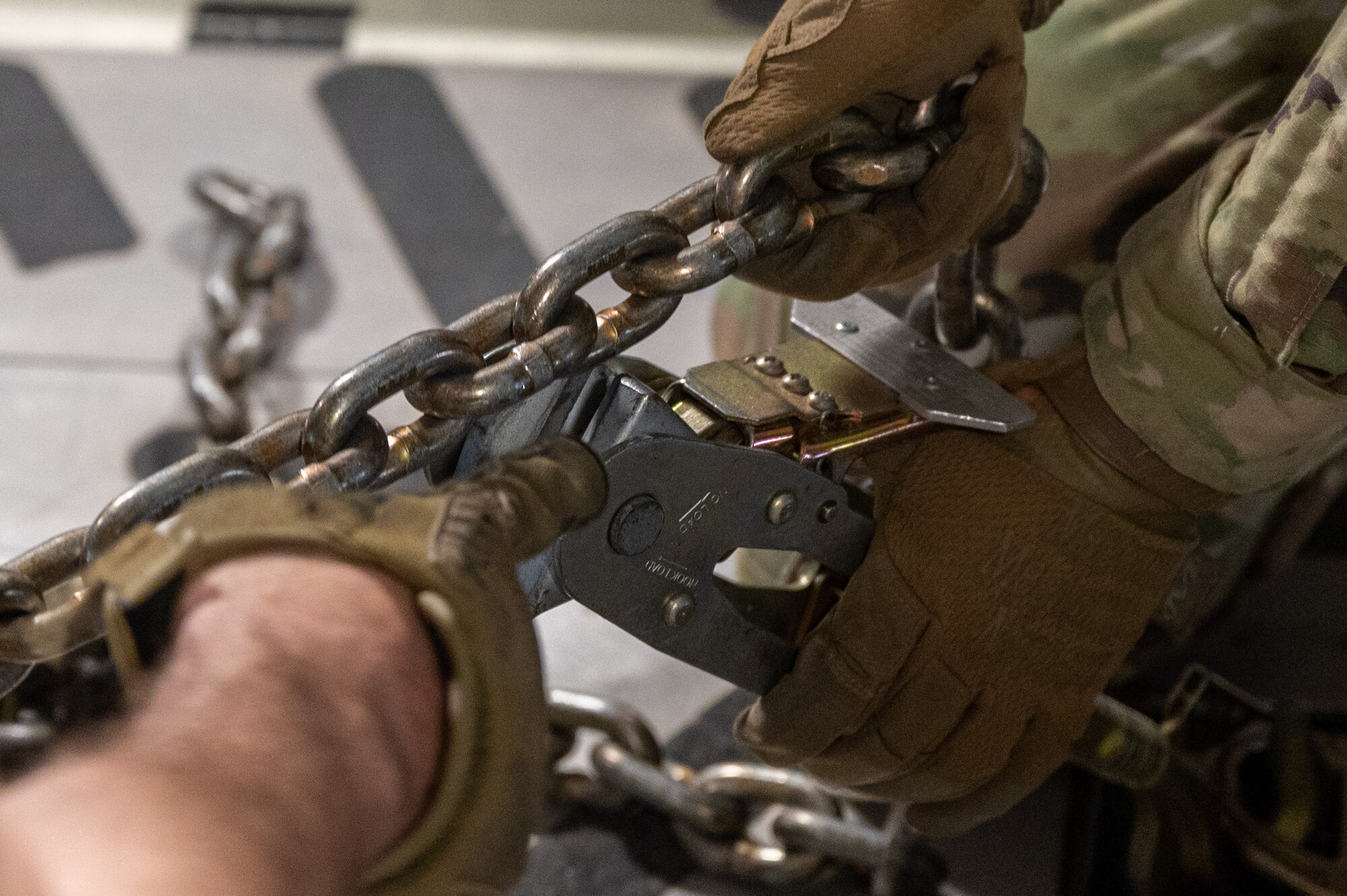 Close-up of hands securing chains.