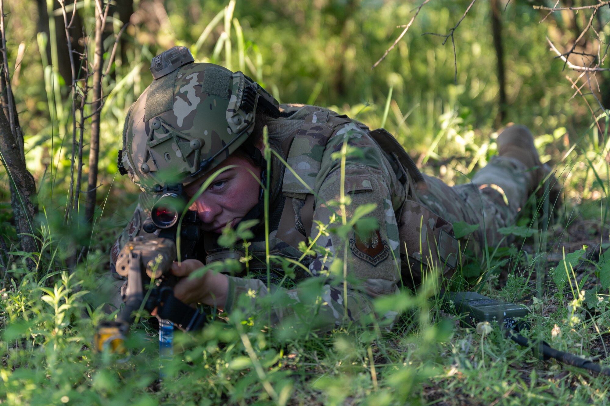 A security forces Airman laying on the ground with a weapon.