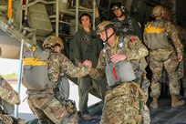 Sgt. 1st Class Christopher Lamp, Jumpmaster and Medic with Headquarters and Headquarters Company, U.S. Army Civil Affairs and Psychological Operations Command (Airborne), helps his fellow Soldiers into a U.S. Marine KC-130 aircraft that will transport them to Sicily Drop Zone, Ft. Bragg, N.C., for their static line tail ramp jump. The May 1, 2021, jump was a chance for the HHC Soldiers to refresh their skills and jump qualifications.