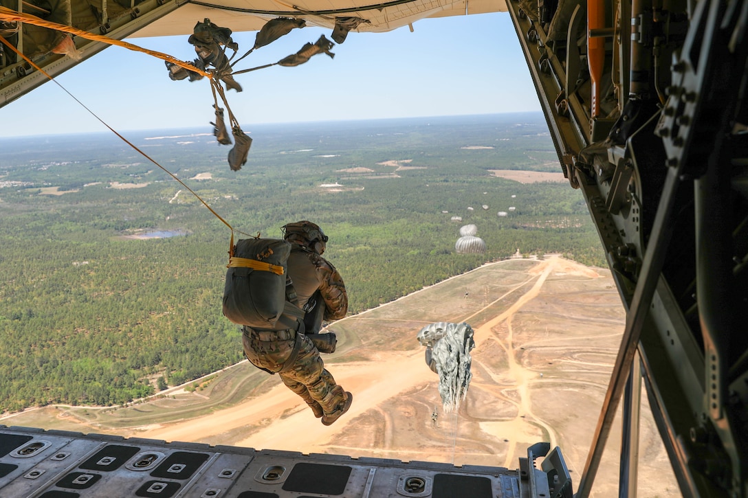 Feet and knees together, elbows in, Headquarters and Headquarters Company, U.S. Army Civil Affairs and Psychological Operations Command (Airborne) Soldiers exit a U.S. Marine KC-130 aircraft during a static line jump over Sicily Drop Zone, Ft. Bragg, N.C., May 1, 2021. The tail ramp jump allowed Soldiers the opportunity to refresh their skills and update their jump qualifications.