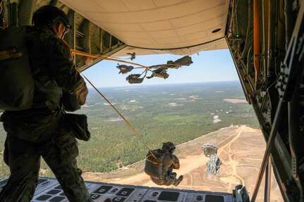 Blue skies and clear visibility as Soldiers from Headquarters and Headquarters Company, U.S. Army Civil Affairs and Psychological Operations Command (Airborne) exit a U.S. Marine KC-130 aircraft during a static line jump over Sicily Drop Zone, Ft. Bragg, N.C., May 1, 2021. The tail ramp jump allowed Soldiers the opportunity to refresh their skills and update their jump qualifications.