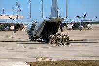 Soldiers from Headquarters and Headquarters Company, U.S. Army Civil Affairs and Psychological Operations Command (Airborne) prepare to board a U.S. Marine KC-130 aircraft that will drop them over Sicily Drop Zone, Ft. Bragg, N.C., May 1, 2021. Prior to boarding, the Soldiers are individually inspected by jumpmaster safeties to ensure their riggings are correct and combat loads are properly secured.