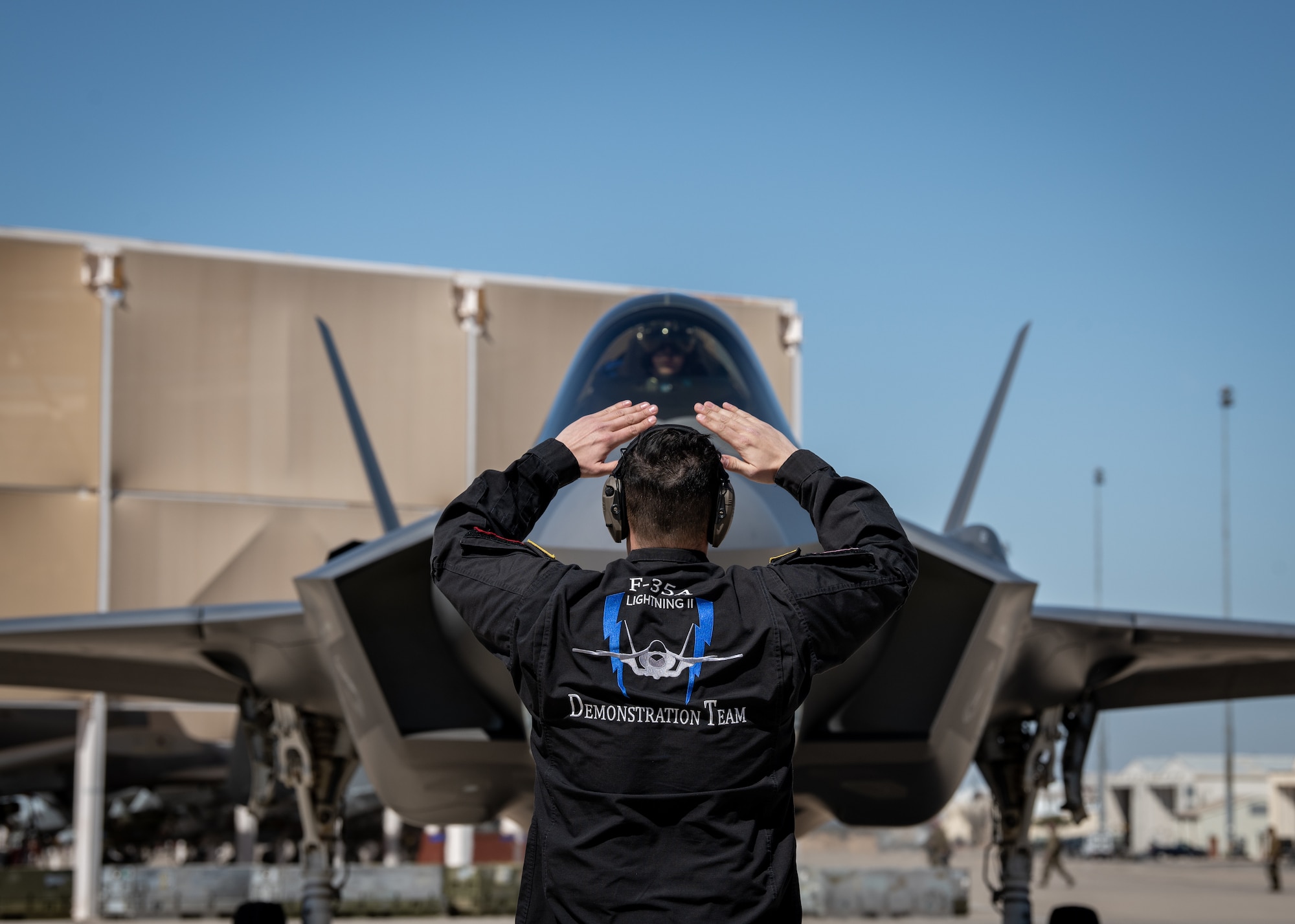 An Air Force maintainer marshals in an F-35A Lightning II fighter jet.