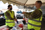 Reserve Senior Airman Danielle Ippolito, 944th Medical Squadron nurse, and Army Guard Spc. Karston Gardner, combat medic, 856th Military Police Company, prepare to vaccinate Salt River Pima-Maricopa Indian Community residents March 26, 2021. Service members are augmenting COVID-19 vaccination sites for communities with low staffing and high demand.