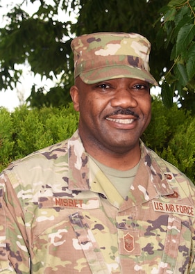 Chief Master Sgt. Winstone Nisbet, 459th Mission Support Group Superintendent, poses for a photo May 5, 2021, at Joint Base Andrews, Md. Nesbit is also a full-time Deputy U.S. Marshal with the U.S. Marshals Service. There, he is assigned to Strategic National Stockpile Security Operations and is currently on a task force providing armed security for all vaccine movement across the United States. (U.S. Air Force photo by Staff Sgt. Cierra Presentado/Released)