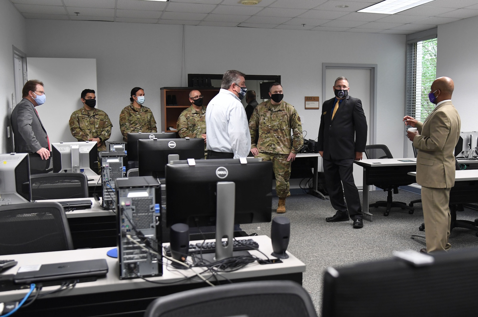 Keesler personnel tour the National Test Center room during the National Test Center reopening ceremony inside the Sablich Center at Keesler Air Force Base, Mississippi, May 12, 2021. After being closed for over a year, the center, which is managed by Bellevue University, offers free CLEP and DANTES Subject Standardized Test exams to military members. (U.S. Air Force photo by Kemberly Groue)