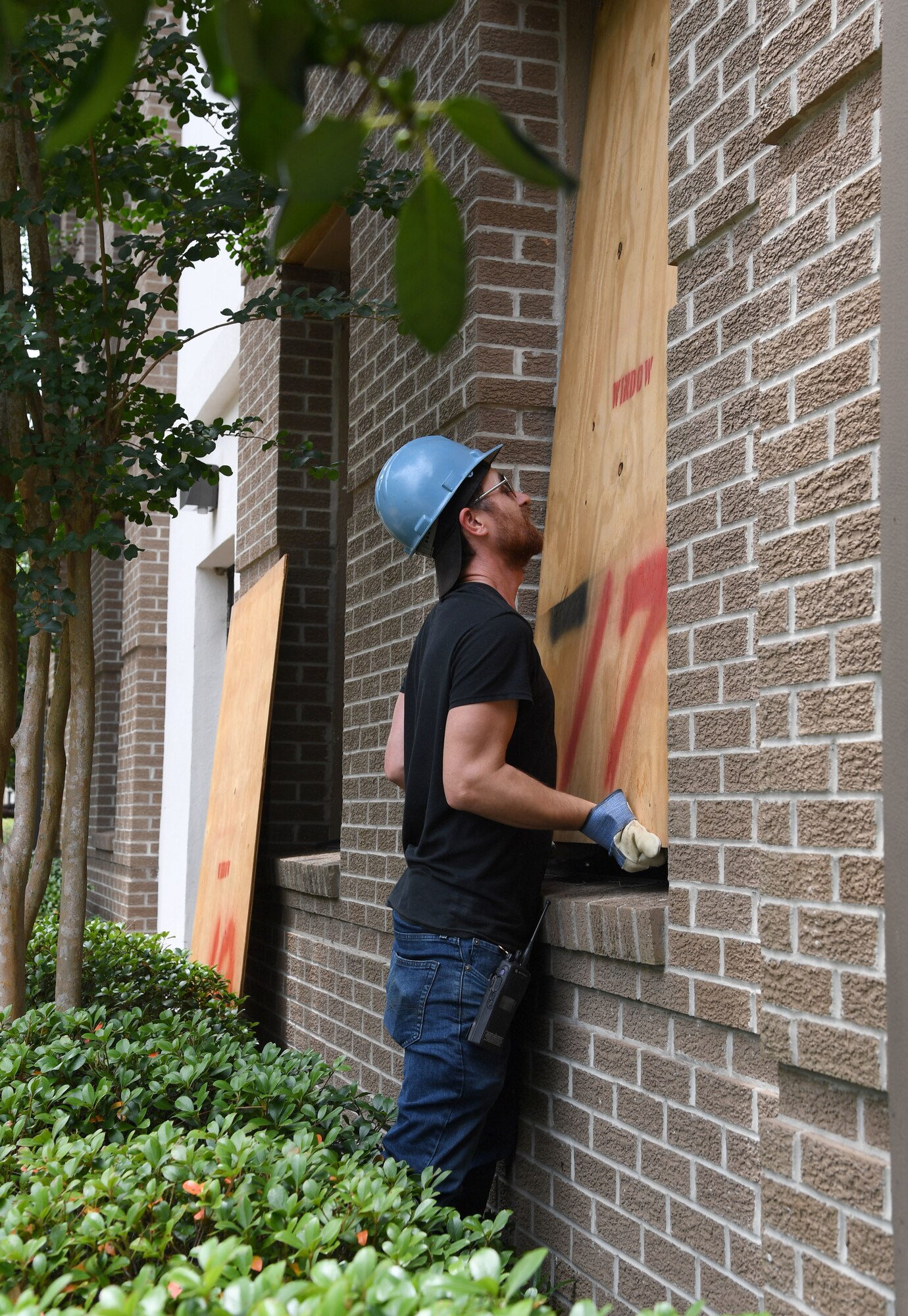 Thomas Frisbie, Vectrus locksmith, secures a board on a window of the 81st Training Wing headquarters building during a hurricane exercise at Keesler Air Force Base, Mississippi, May 12, 2021. Keesler personnel participate in exercise scenarios in preparation for hurricane season. (U.S. Air Force photo by Kemberly Groue)