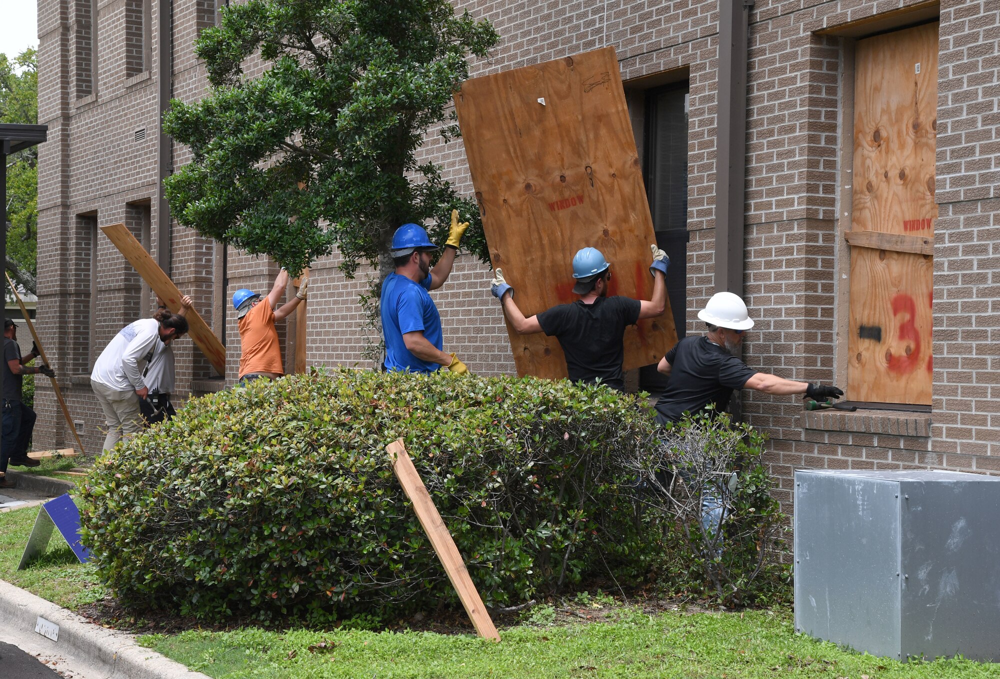 Vectrus personnel secures boards on windows of the 81st Training Wing headquarters building during a hurricane exercise at Keesler Air Force Base, Mississippi, May 12, 2021. Keesler personnel participate in exercise scenarios in preparation for hurricane season. (U.S. Air Force photo by Kemberly Groue)