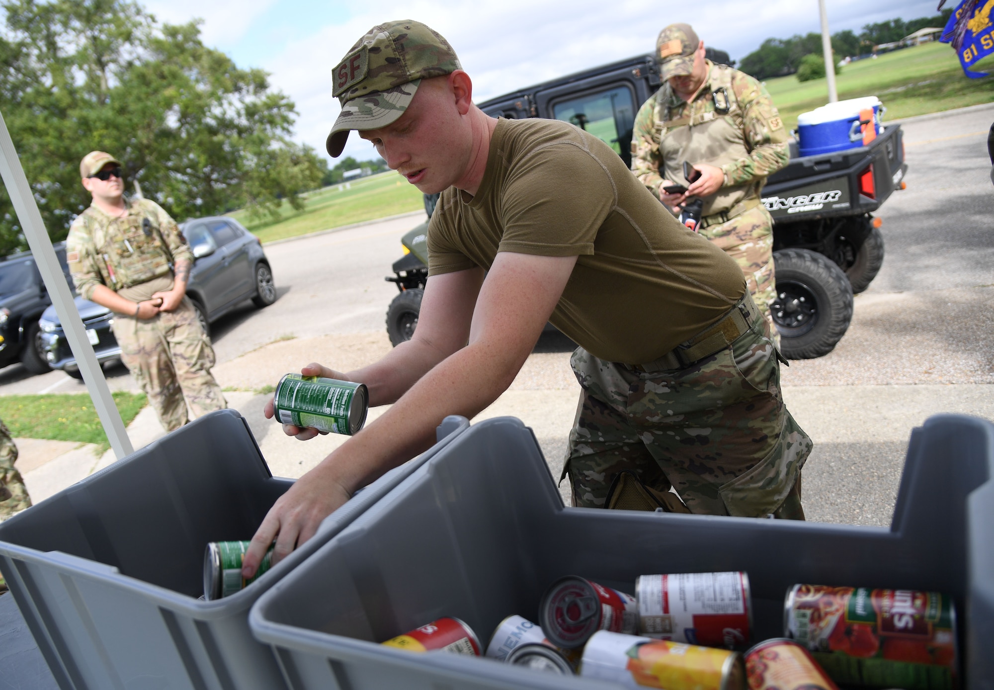 U.S. Air Force Staff Sgt. Trevor Perley, 81st Security Forces Squadron supply NCO in charge, unloads canned goods from his ruck sack following an 81st SFS Ruck March/Canned Food Drive at Keesler Air Force Base, Mississippi, May 13, 2021. The event was held during National Police Week, which recognizes the men and women in law enforcement. (U.S. Air Force photo by Kemberly Groue)