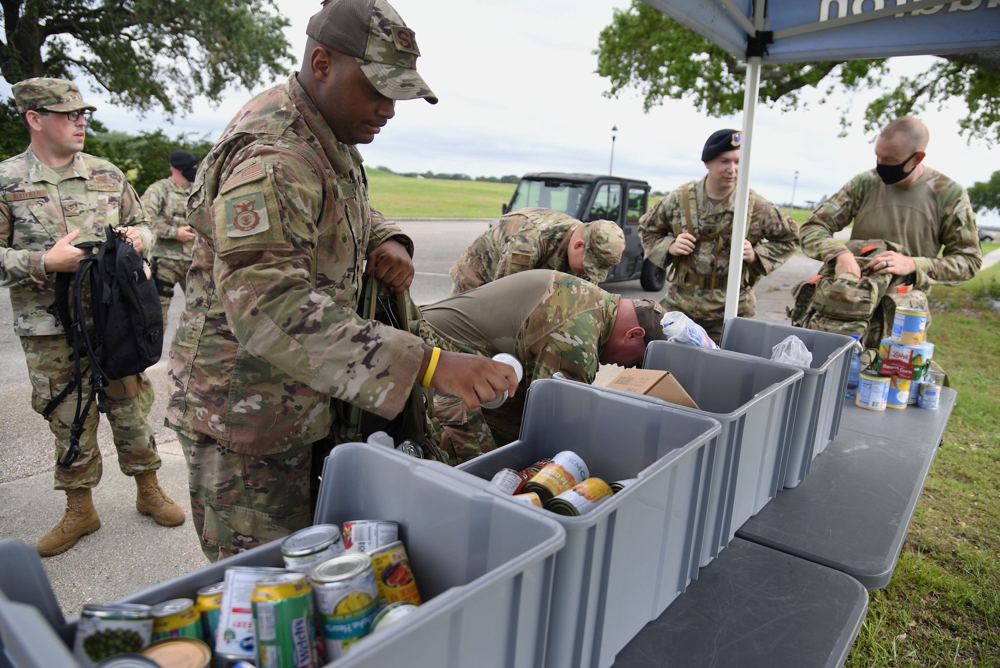 Members of the 81st Security Forces Squadron unload canned goods from their ruck sacks following an 81st SFS Ruck March/Canned Food Drive at Keesler Air Force Base, Mississippi, May 13, 2021. The event was held during National Police Week, which recognizes the men and women in law enforcement. (U.S. Air Force photo by Kemberly Groue)