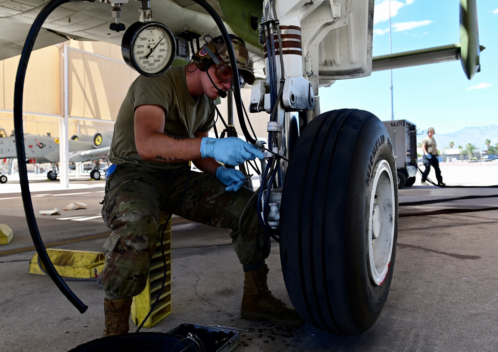 photo of an airman performing maintenance on the hydraulics system of an A-10 Thunderbolt II aircraft