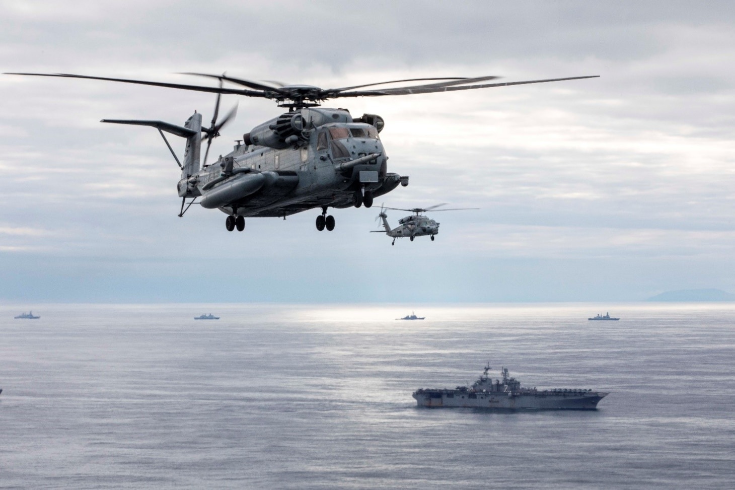 A CH-53 Stallion helicopter, left, attached to Marine Medium Tiltrotor Squadron (VMM) 162 (Reinforced) and an MH-60S Sea Hawk helicopter from the “Chargers” of Helicopter Sea Combat Squadron (HSC) 26 fly alongside the Wasp-class amphibious assault ship USS Iwo Jima (LHD 7) during a photo exercise, May 17, 2021. Iwo Jima is underway in the Atlantic Ocean with Amphibious Squadron 4 and the 24th Marine Expeditionary Unit (MEU) as part of the Iwo Jima Amphibious Ready Group.