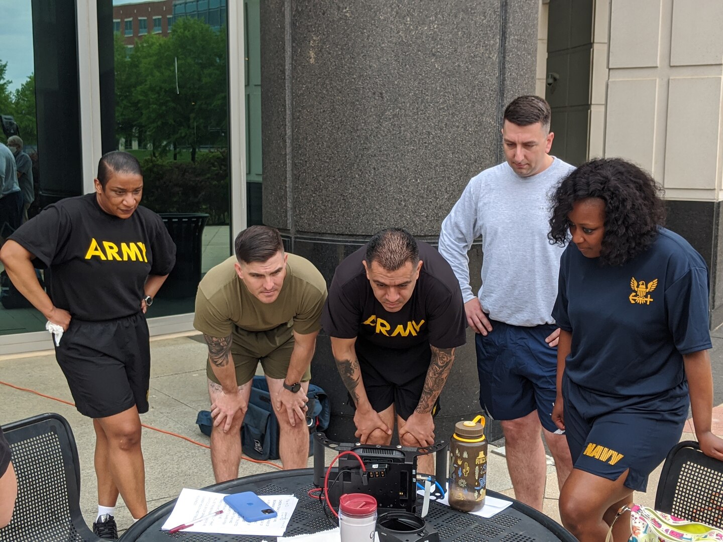 Two female and three male officers view video playback.