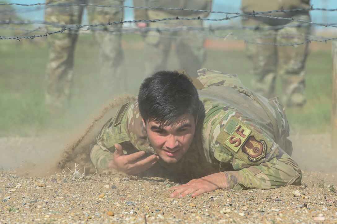 Airman 1st Class Wyatt Ramos, 75th Security Forces Squadron, crawls under barb wire during the National Police Week obstacle course competition May 11, 2021, at Hill Air Force Base, Utah. The obstacle course competition was one of many events 75th SFS hosted to commemorate the week to honor the sacrifices of the law enforcement community. (U.S. Air Force photo by Cynthia Griggs)