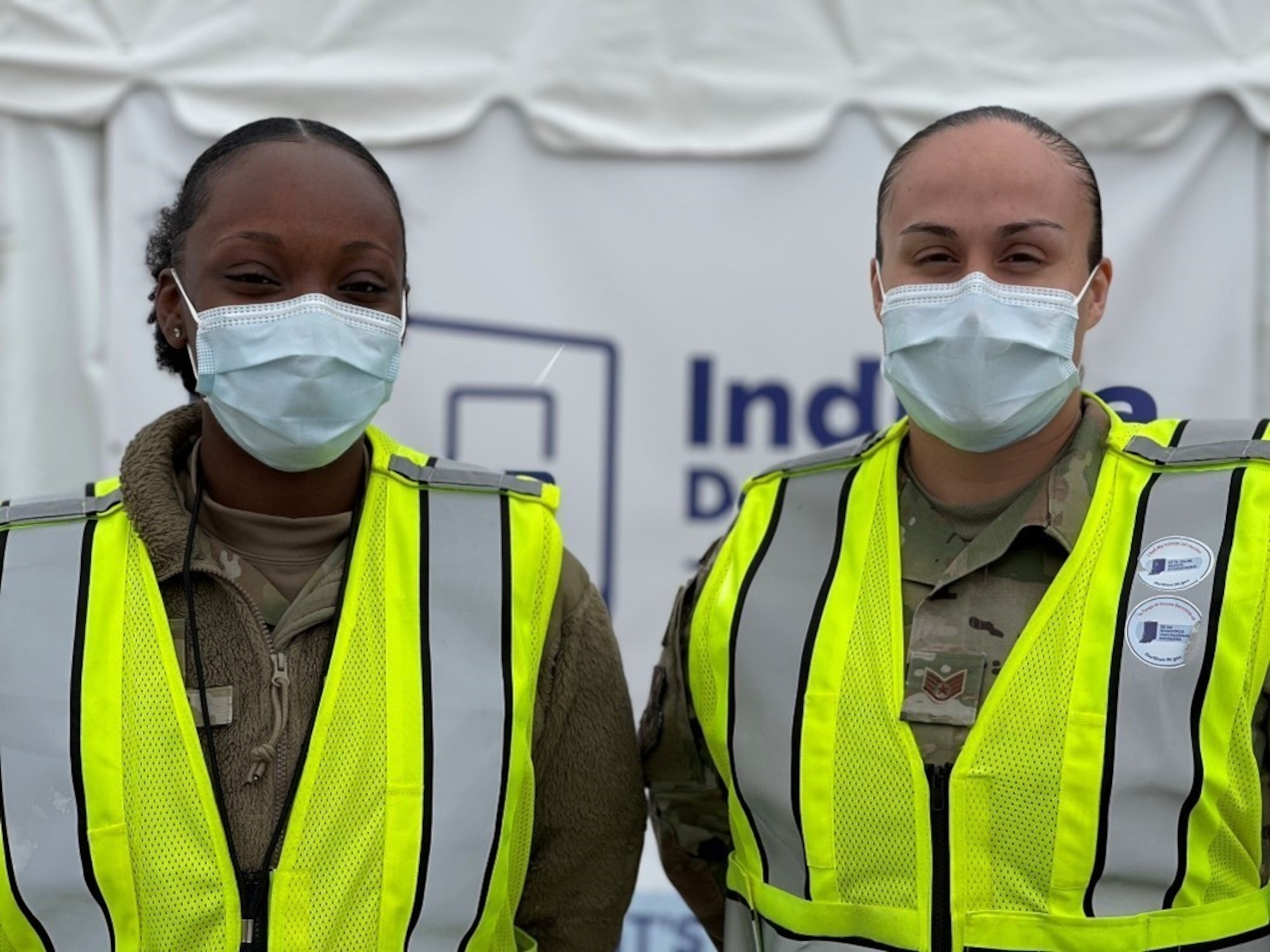 U.S. Air Force Airman First Class Taneia Thomas, left, and U.S. Air Force Staff Sgt. Saundra Turner, right, medical technicians with the 87th Medical Operations Squadron at McGuire Air Force Base, New Jersey, assigned to the 2nd Detachment, 64th Air Expeditionary Group, pose for a picture in between vaccinations at the state-led, federally supported Community Vaccination Center (CVC) at the former Roosevelt High School in Gary, Indiana, April 29, 2021.  In addition to administering vaccines, the medical professionals assigned to the CVC monitor the care of all patients, before and after each shot, in order to maintain site safety and respond to any adverse or situation. The CVC supports both drive-up and walk-in appointments and will vaccinate up to 3,000 local community members a day. U.S. Northern Command, through U.S. Army North, remains committed to providing continued, flexible Department of Defense support to the Federal Emergency Management Agency as part of the whole-of-government response to COVID-19. (U.S. Air Force photo by 2Lt Brittney Sturgis, 64th Air Expeditionary Group, 2nd Detachment.)