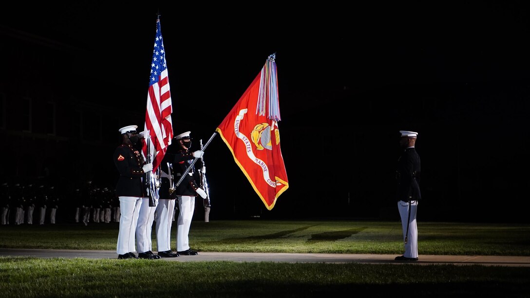 Marines with the Official U.S. Marine Corps Color Guard present the colors during the national anthem at the Friday Evening Parade at Marine Barracks Washington, D.C., May 14, 2021.  The Deputy Commandant for Combat Development and Integration and Commanding General of Marine Corps Combat Development Command Lt. Gen. Eric M. Smith, was the hosting official, and the guests of honor were the 12th NASA Administrator the Honorable Charles F. Bolden, Jr., Maj. Gen., USMC (Ret.); NASA Astronaut and active duty Marine Lt. Col. Nicole A. Man; and NASA Astronaut and active duty Marine Maj. Jasmin Moghbeli. (U.S. Marine Corps photo by Sgt. Jason Kolela)