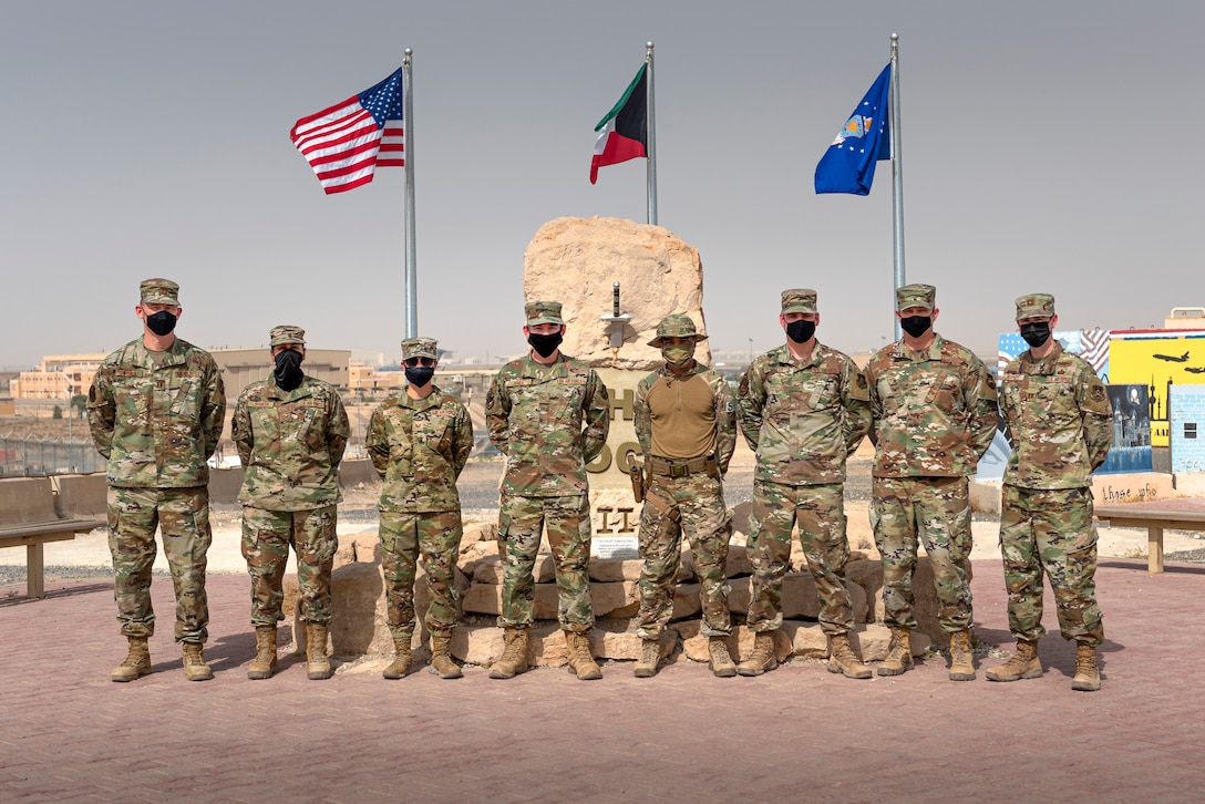 U.S. Airmen from the Wing Innovation Team stand in front of The Rock at Ali Al Salem Air Base, Kuwait, May 13, 2021. These Airmen, in various career fields across the installation, had helping hands in creating a product that automates about 90% of data scrubs unit travel representatives are required to do monthly. (U.S. Air Force photo by Senior Airman Taryn Butler)