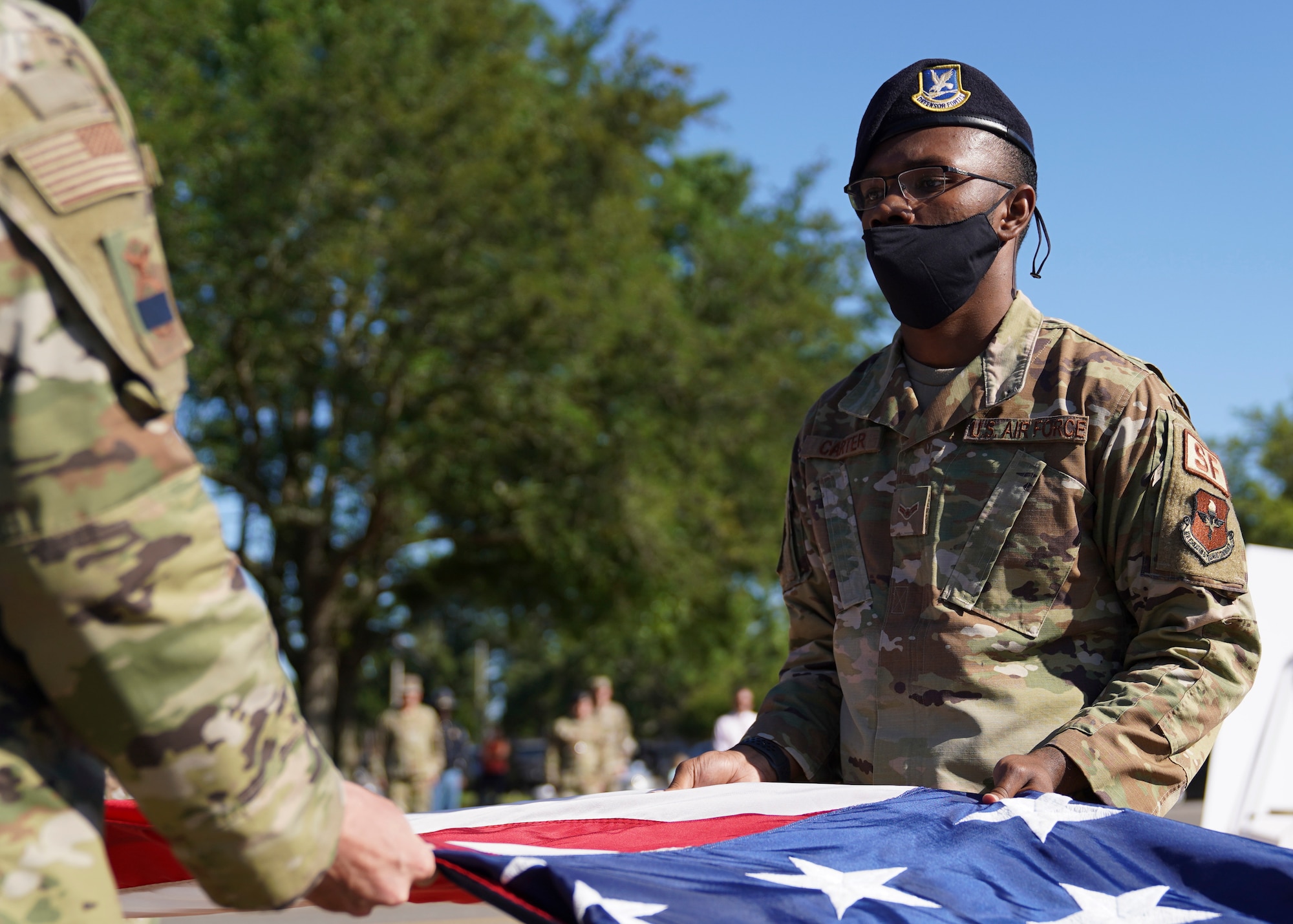 U.S. Air Force Airman 1st Class LaDarian Carter, 81st Security Forces Squadron patrolman, folds the U.S. flag during the Police Week retreat ceremony at Keesler Air Force Base, Mississippi, May 14, 2021. The event was held during National Police Week, recognizing the men and women in law enforcement. (U.S. Air Force photo by Senior Airman Spencer Tobler)