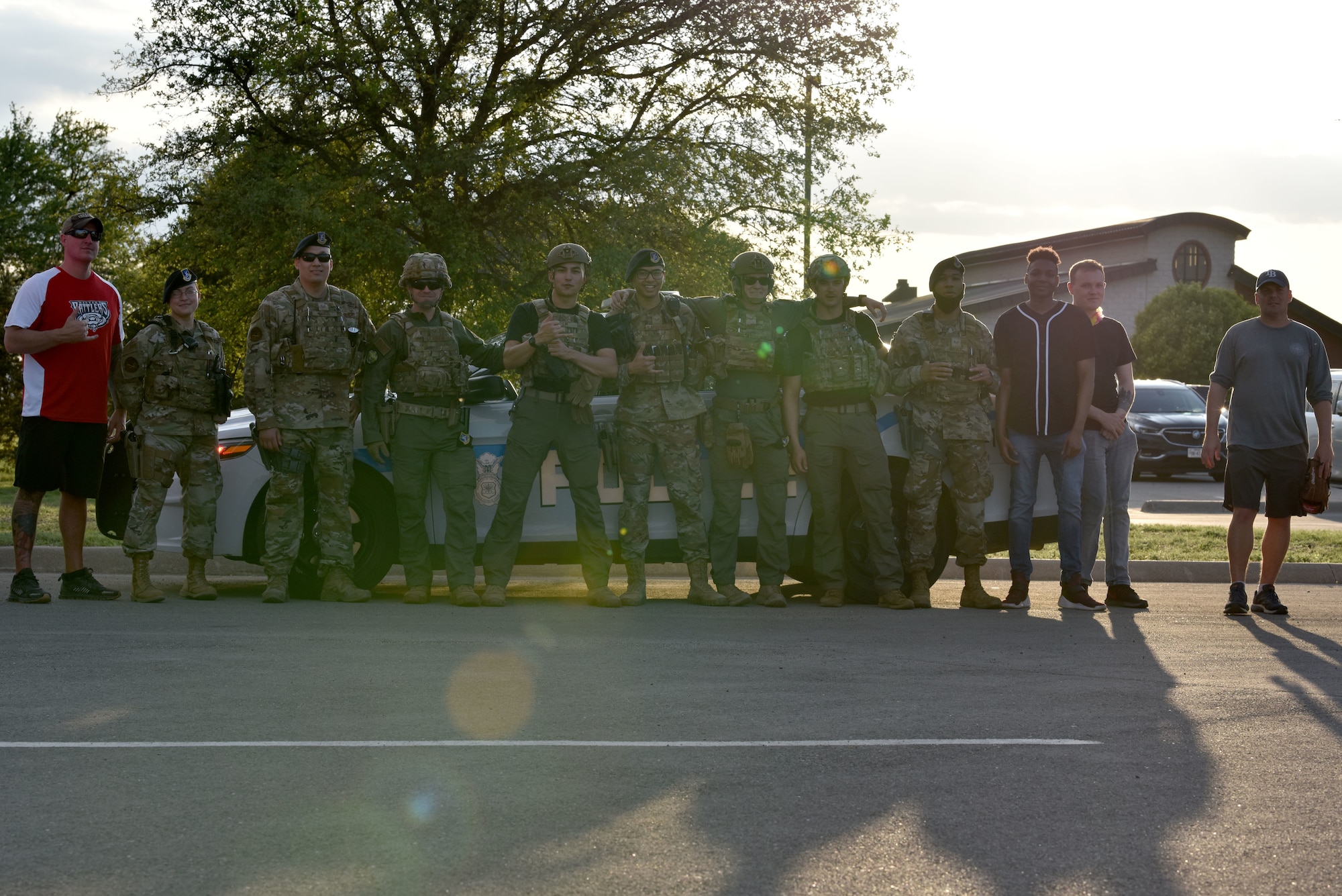 Group of Airmen standing in front of a police car.