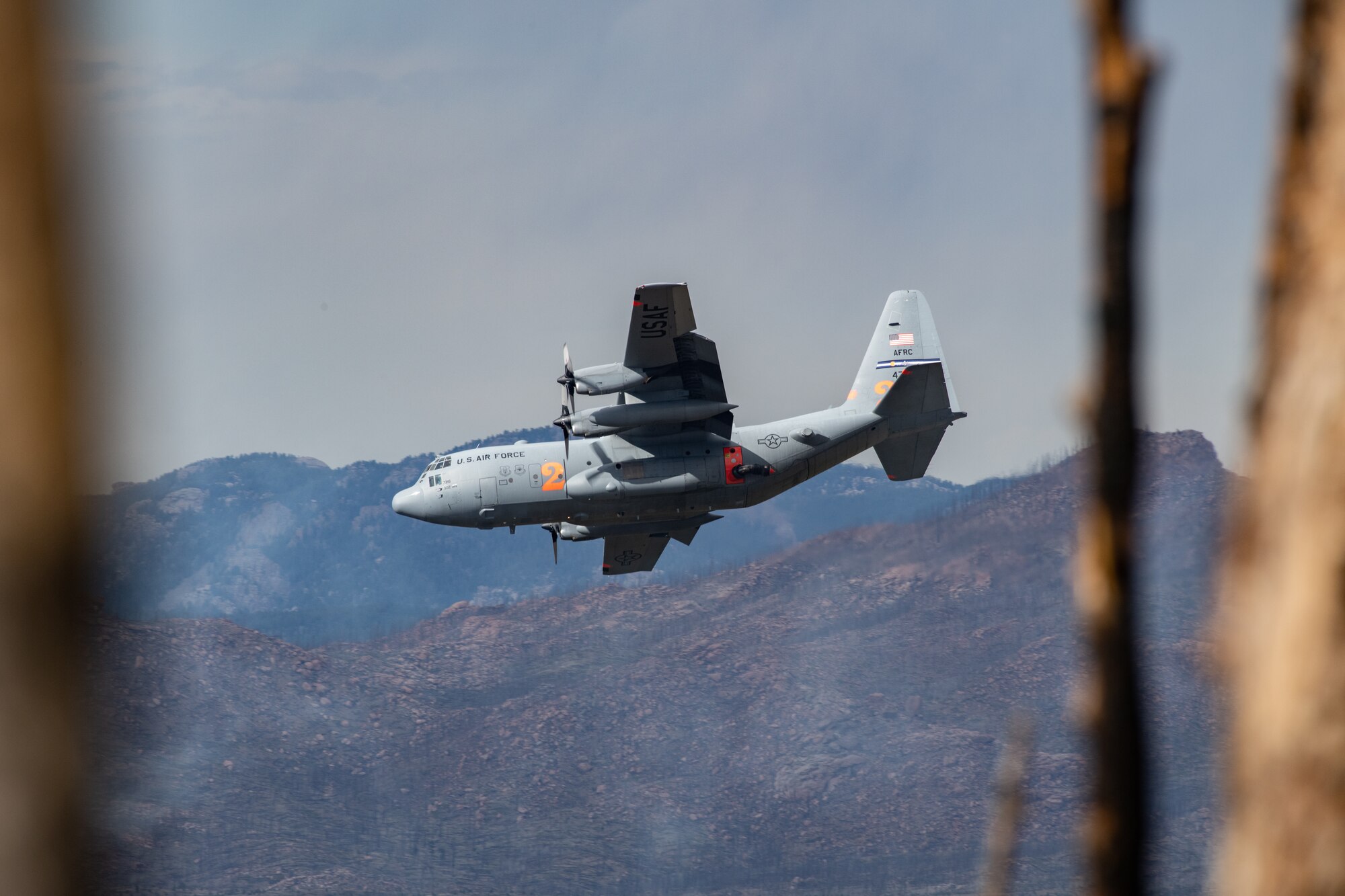 C-130 dropping potable water on mountain ridge