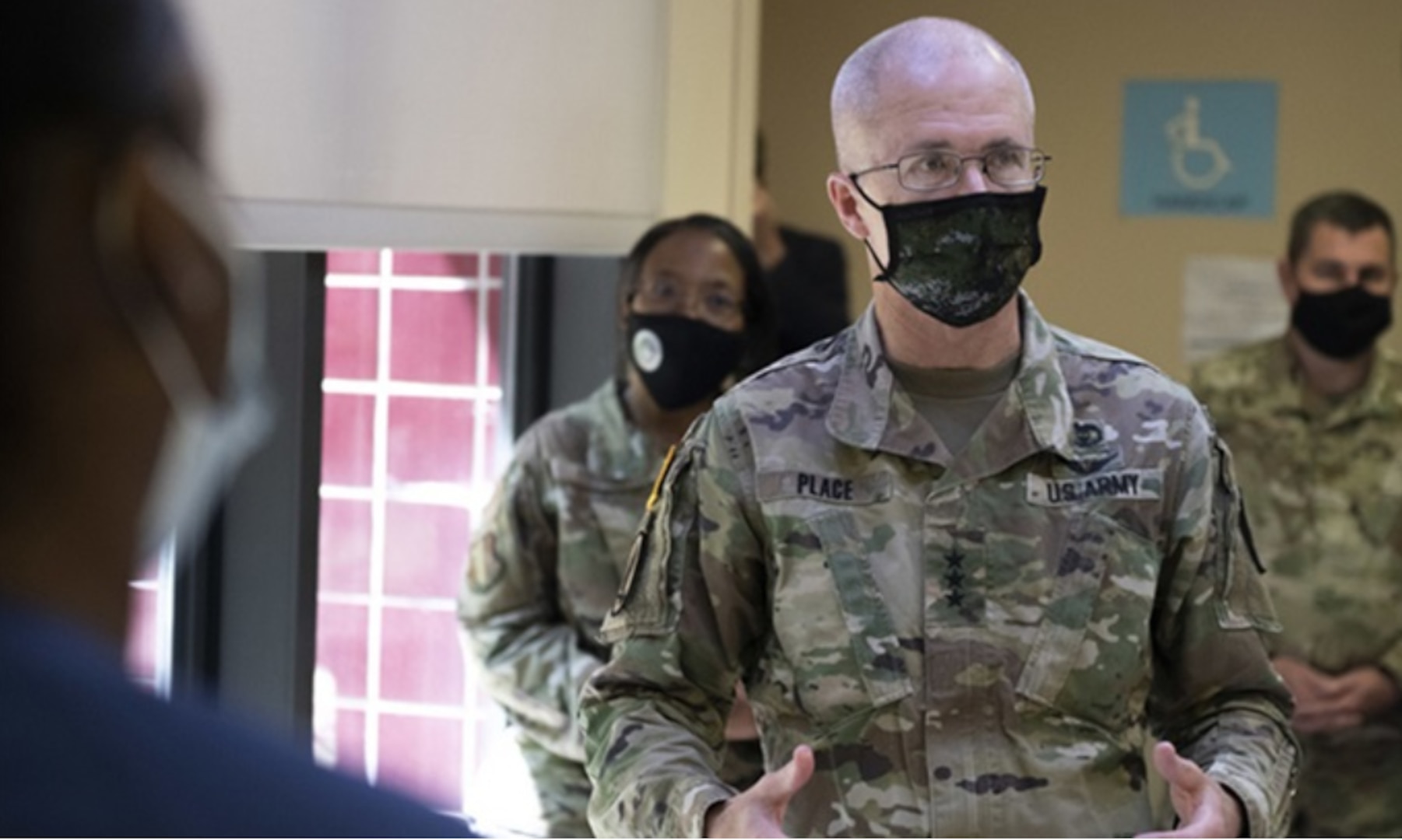 Senior Airman Jessica McVean, 60th Inpatient Therapeutic Squadron technician, briefs Army Lt. Gen. Ronald Place, Defense Health Agency director, May 10, 2021, at Travis Air Force Base, California.