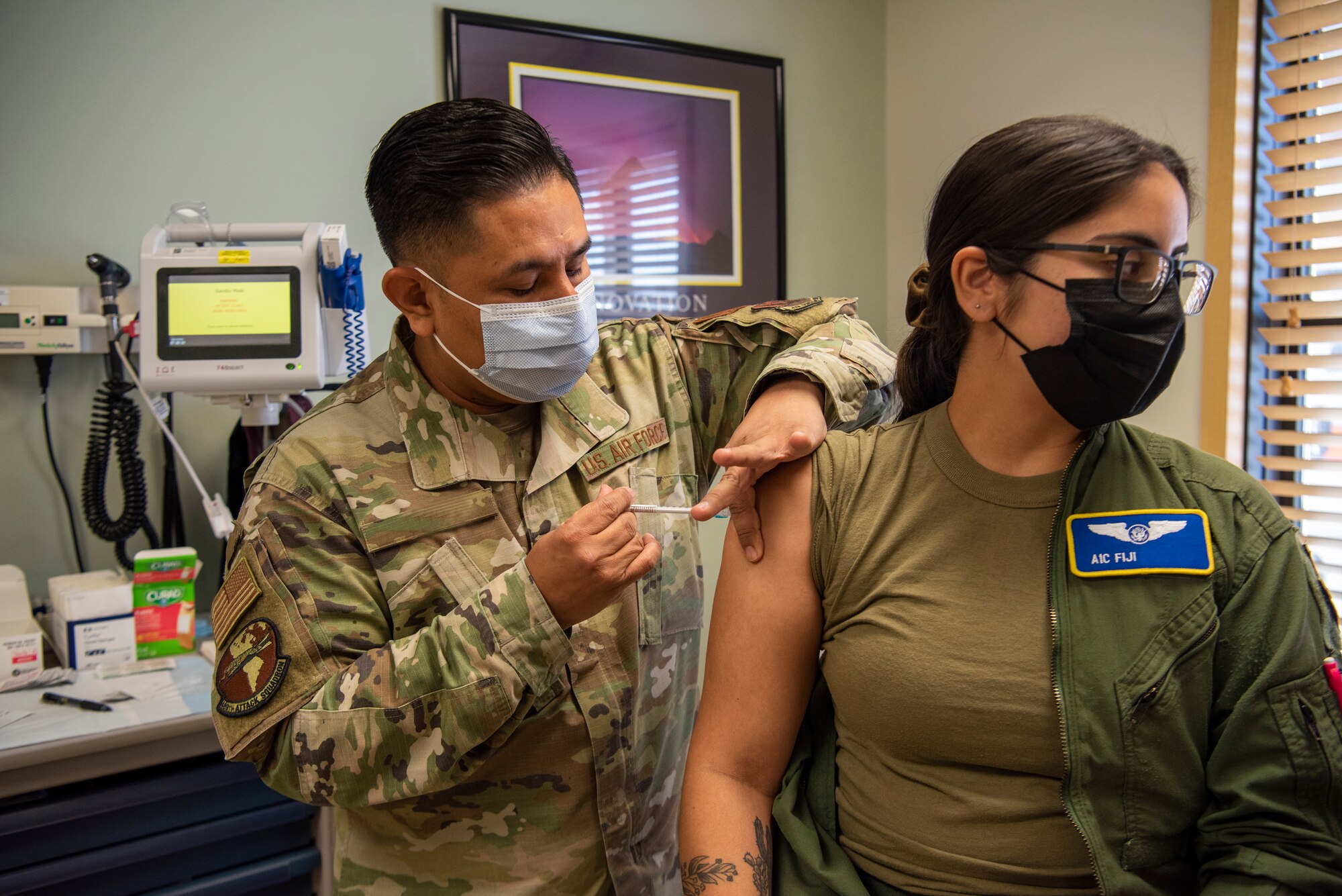 Tech Sgt. Benigno gives a COVID-19 vaccine shot to Airman 1st Class Fiji.