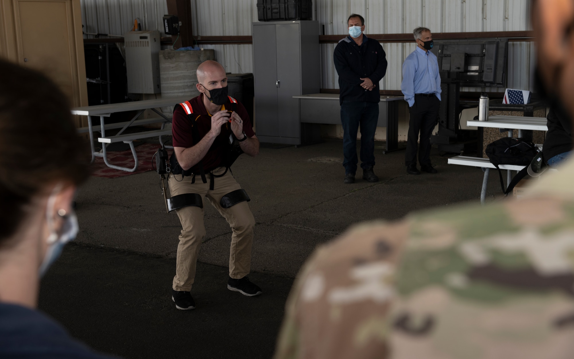 Brandon Martin, Arizona State University doctor of philosophy student, demonstrates how the Aerial Porter Exoskeleton functions May 14, 2021, at Travis Air Force Base, California. The Aerial Porter Exoskeleton is a piece of equipment designed to reduce strain when lifting various items. (U.S. Air Force photo by Senior Airman Cameron Otte)