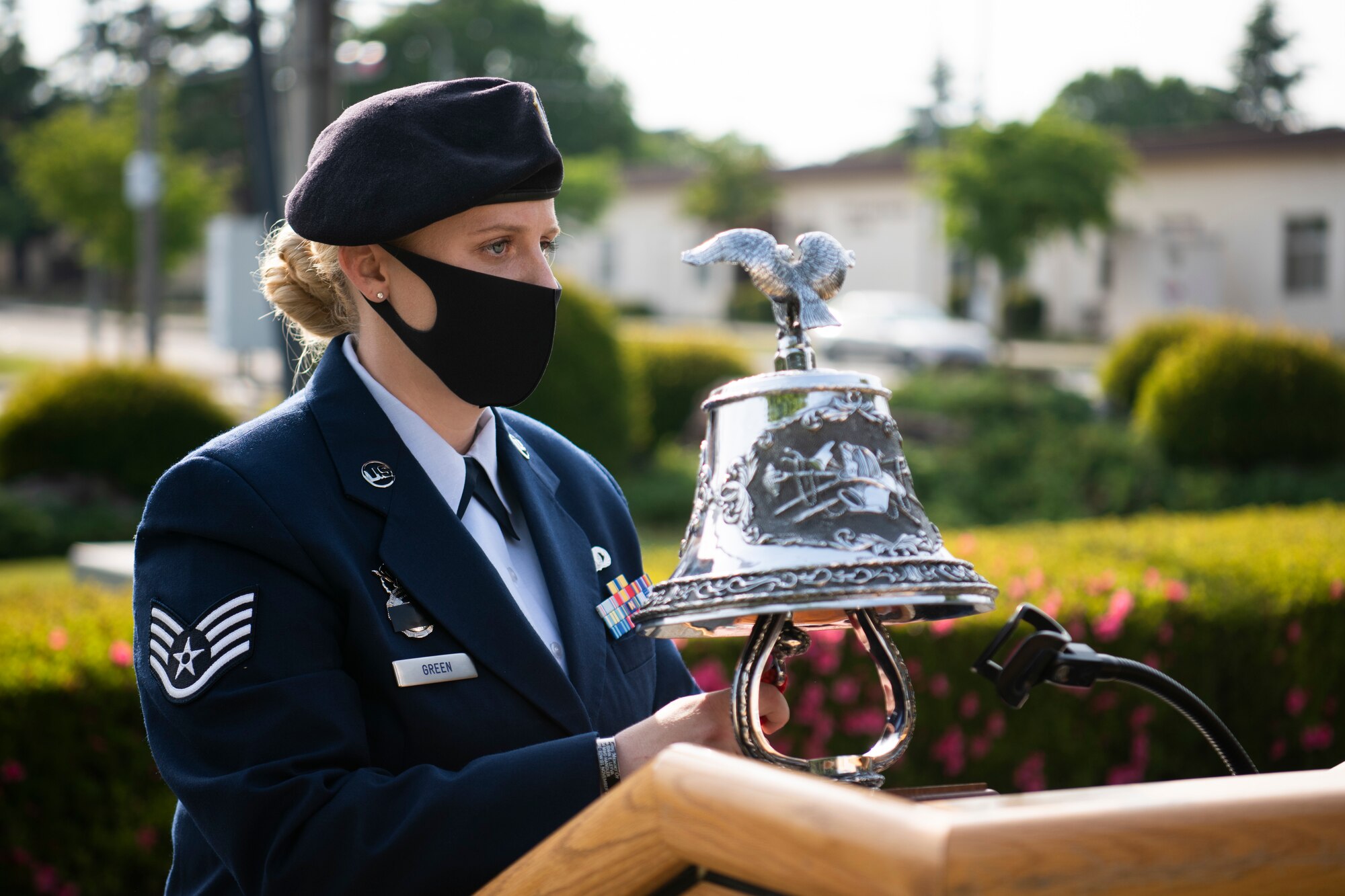 Staff Sgt. Ashleigh Green, 374th Security Forces Squadron military working dog handler, rings a bell during the National Police Week retreat ceremony at Yokota Air Base, Japan, May 14, 2021. The ringing of the bell signifies the end of watch for the individuals who fell in the line of duty. (U.S. Air Force photo by Staff Sgt. Braden Anderson)