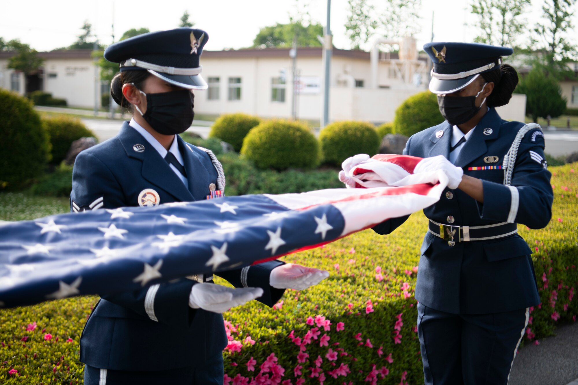 Base honor guard members fold the American flag during the National Police Week retreat ceremony at Yokota Air Base, Japan, May 14, 2021. The honor guard lowered both the American and Japanese flag during a ceremony dedicated to recognizes law enforcement individuals. (U.S. Air Force photo by Staff Sgt. Braden Anderson)