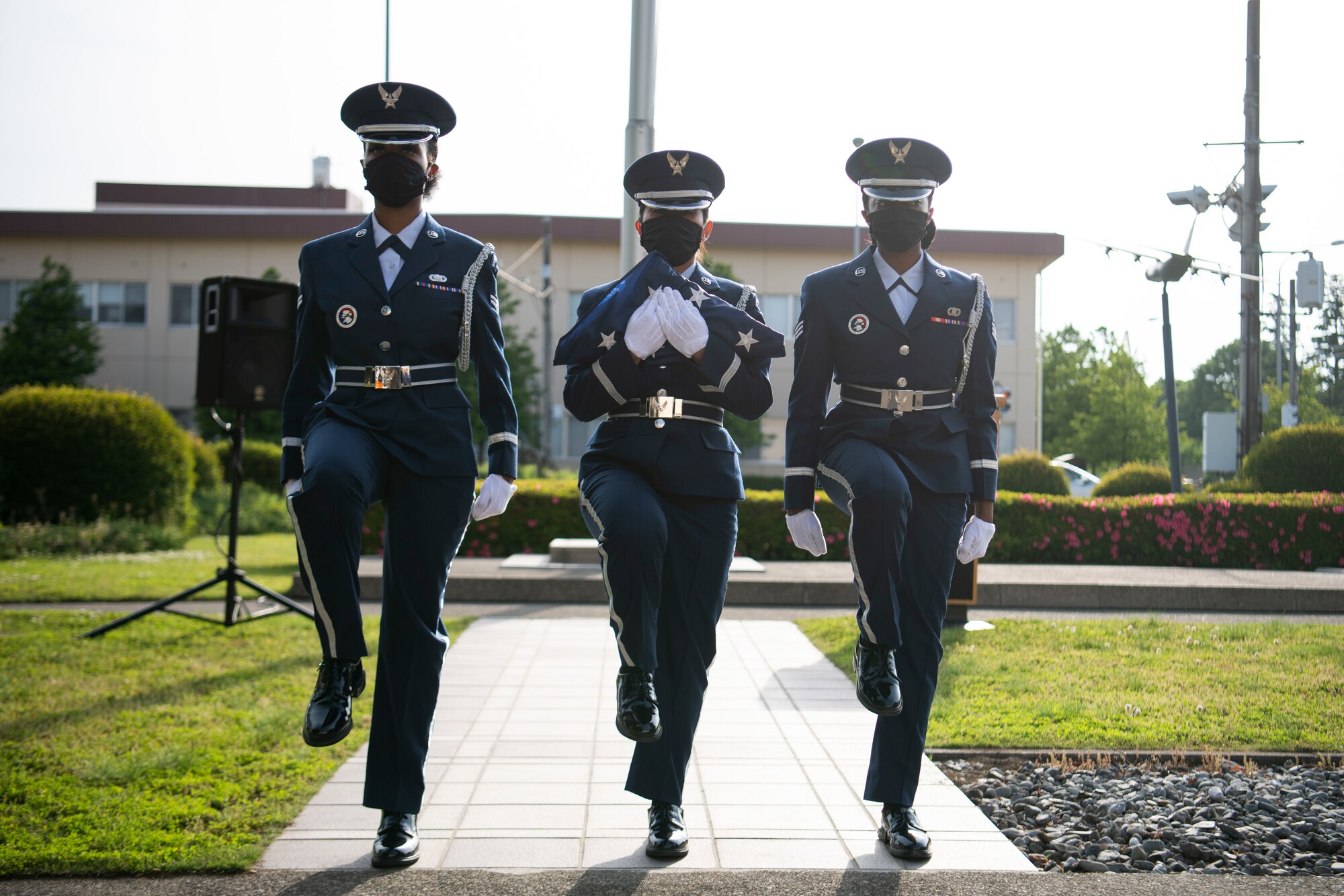 Base honor guard members march with the American flag during the National Police Week retreat ceremony at Yokota Air Base, Japan, May 14, 2021. The retreat ceremony featured speeches, the lowering of the American and Japanese flags and a bell ringing to signify the end of watch for fallen law enforcement. (U.S. Air Force photo by Staff Sgt. Braden Anderson)