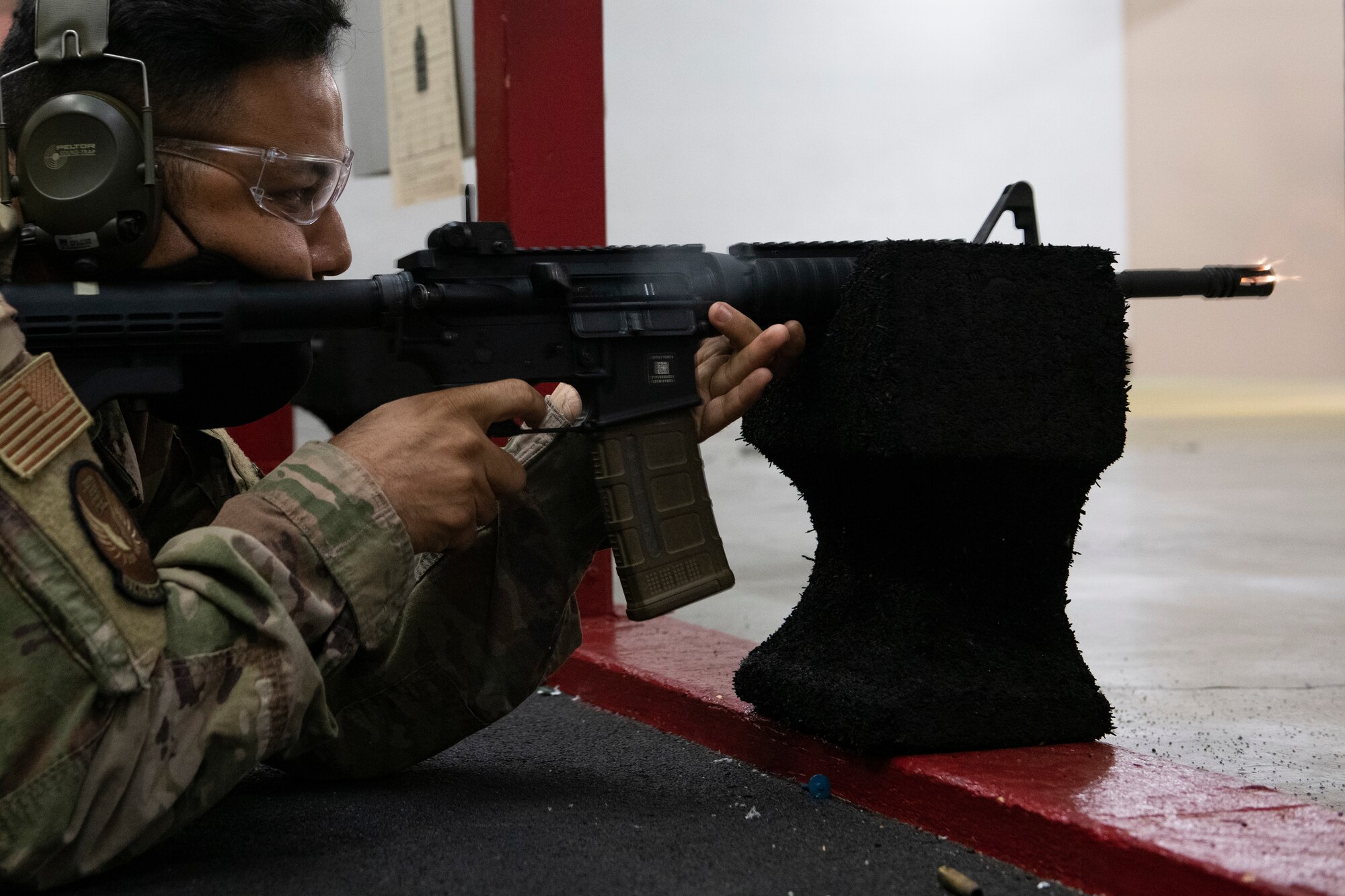 Tech. Sgt. Kelly Martin, 374th Contracting Squadron Airlift Acquisition NCO in charge, fires an M4 carbine while competing during National Police Week at Yokota Air Base, Japan, May 12, 2021. Martin and other competitors had to fire while standing, sitting and prone to get points. (U.S. Air Force photo by Staff Sgt. Joshua Edwards)