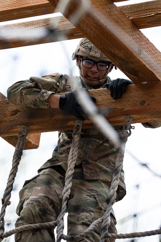 Alaska Army National Guardsman Spc. Jysamon Sanouvong, a military police officer assigned to the 49th Military Police Ground Based Interceptor Security Company, climbs over a pillar in an obstacle course as a part of the Alaska Army National Guard Best Warrior Competition May 15, 2021 at Joint Base Elmendorf-Richardson. The Best Warrior Competition recognizes Soldiers who demonstrate commitment to the Army values and embody the warrior ethos. (U.S. Army National Guard photo by Spc. Marc Marmeto).