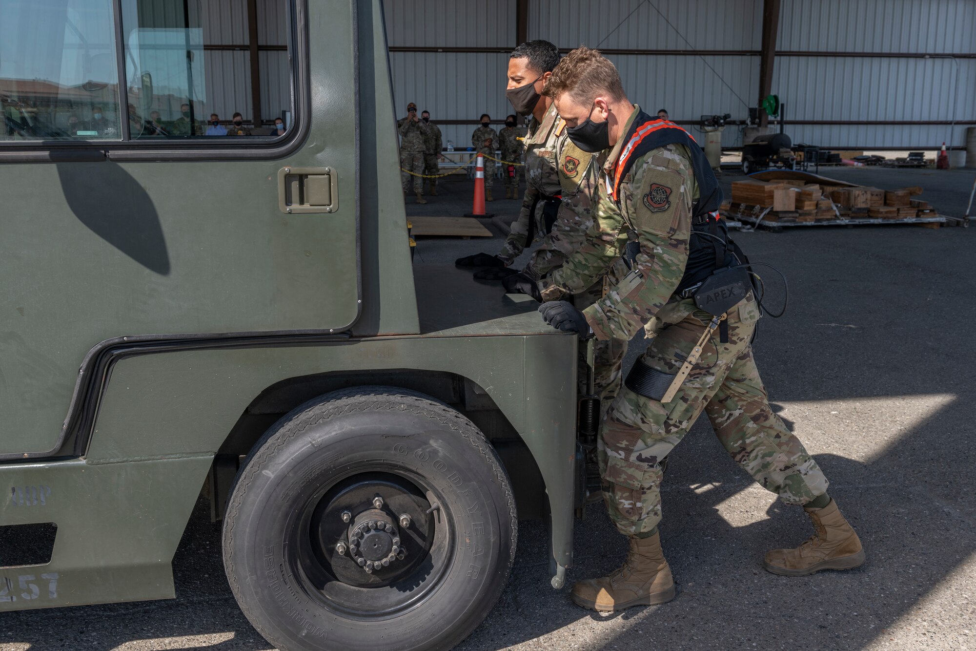 Airman 1st Class Xaviar Archangel, 60th Aerial Port Squadron aerial porter, and Airman 1st Class Kyle Sunderman, 60th APS ramp serviceman, showcase the capabilities of the Aerial Porter Exoskeleton May 14, 2021, at Travis Air Force Base, Calif. The exoskeleton is a piece of equipment designed to reduce strain when lifting various items.