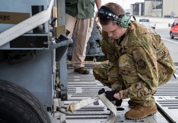 Airman 1st Class Joshua Grant, 9th Airlift Squadron loadmaster, secures cargo to the ramp of a C-5M Super Galaxy at Dover Air Force Base, Delaware, May 16, 2021. The aircraft departed in support of Exercise Mobility Guardian 2021, Air Mobility Command’s largest and longest training event. Airmen are tested through a challenging, realistic and detailed scenario based on real-world challenges. More than 1,800 participants will operate 18 mobility aircraft at six locations in Michigan and Wisconsin during the exercise. (U.S. Air Force photo by Airman 1st Class Cydney Lee)