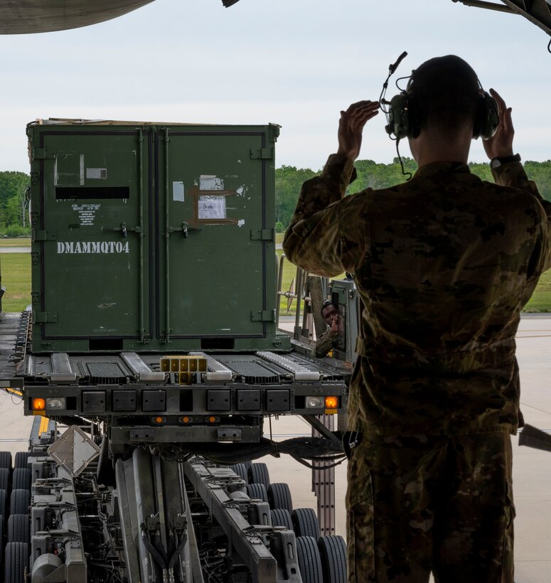 Airman 1st Class Joshua Grant, 9th Airlift Squadron loadmaster, marshals a K-loader to the ramp of a C-5M Super Galaxy at Dover Air Force Base, Delaware, May 16, 2021. The aircraft departed in support of Exercise Mobility Guardian 2021, a joint force exercise aimed at integrating 18 mobility aircraft with fighters, bombers, special operations forces and field artillery to conduct all-domain operations against a highly-capable adversary. (U.S. Air Force photo by Airman 1st Class Cydney Lee)
