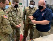 Russ Kropp, a U.S. Army Tank-automotive and Armaments Command employs Logistics Assistance Representative assigned to the 405th Army Field Support Brigade’s Army Field Support Battalion-Germany, shows a group of Soldiers from the 92nd Military Police Company how to check a Humvee brake-torque converter cutout switch.