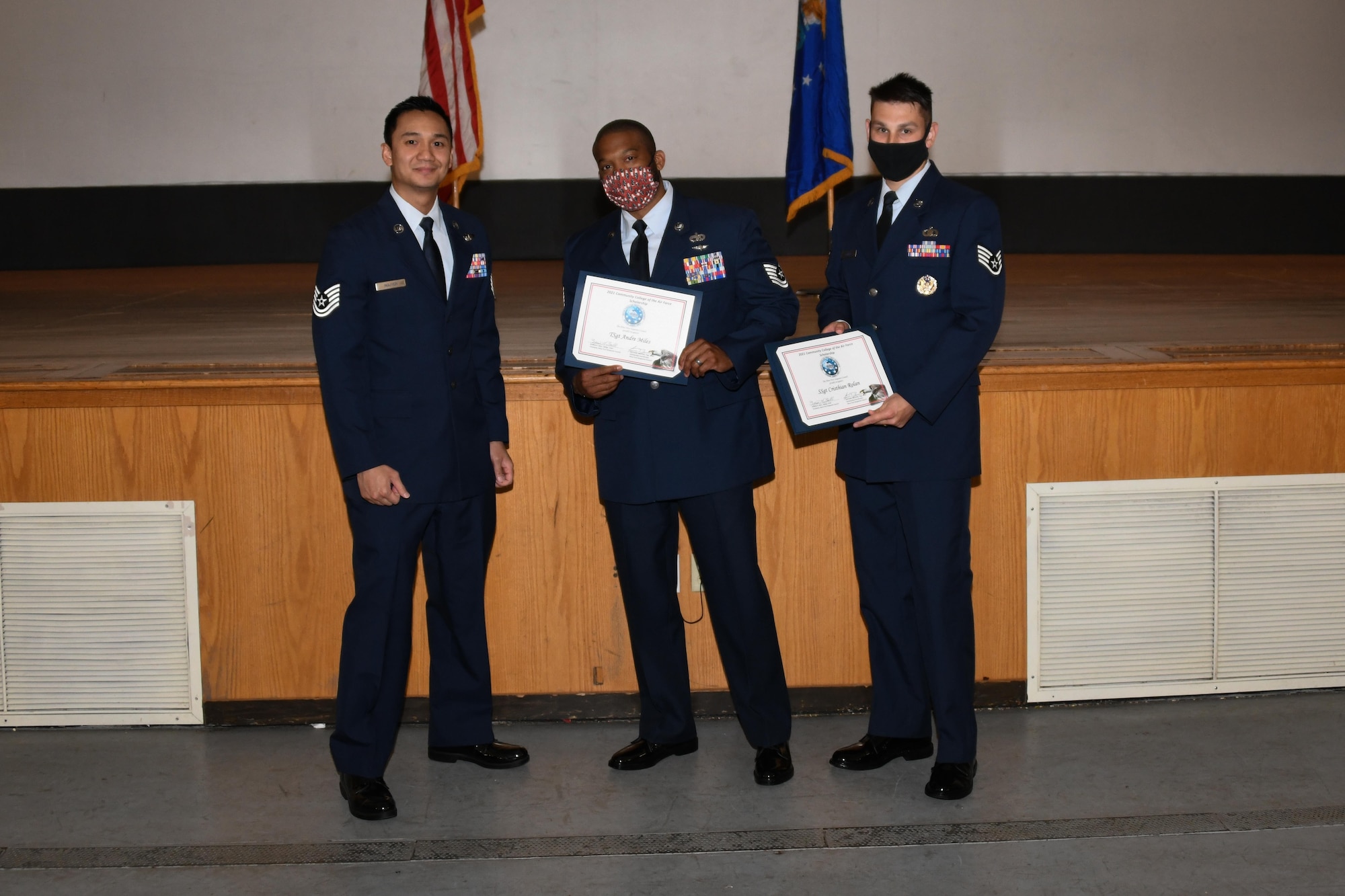 Three men hold certificates.