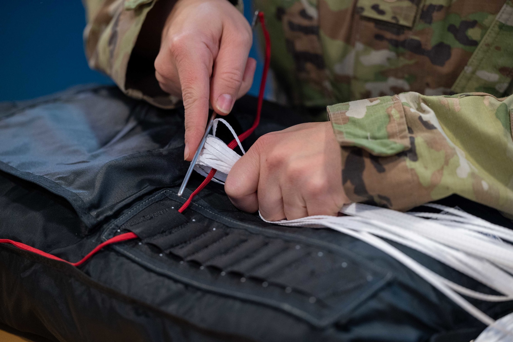 Staff Sgt. Nicole Harper, 436th Operations Support Squadron aircrew flight equipment supervisor, threads lines of a new BA-30 parachute at Dover Air Force Base, Delaware, May 6, 2021. AFE members are responsible for ensuring all flight and safety equipment is in working order on Dover aircraft. (U.S. Air Force photo by Airman 1st Class Faith Schaefer)