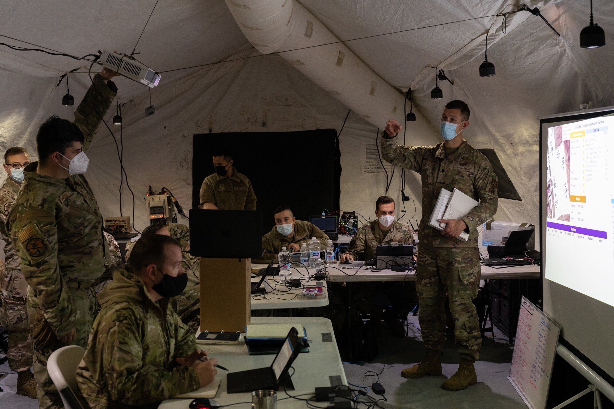A group of Airmen standing in a large tent.