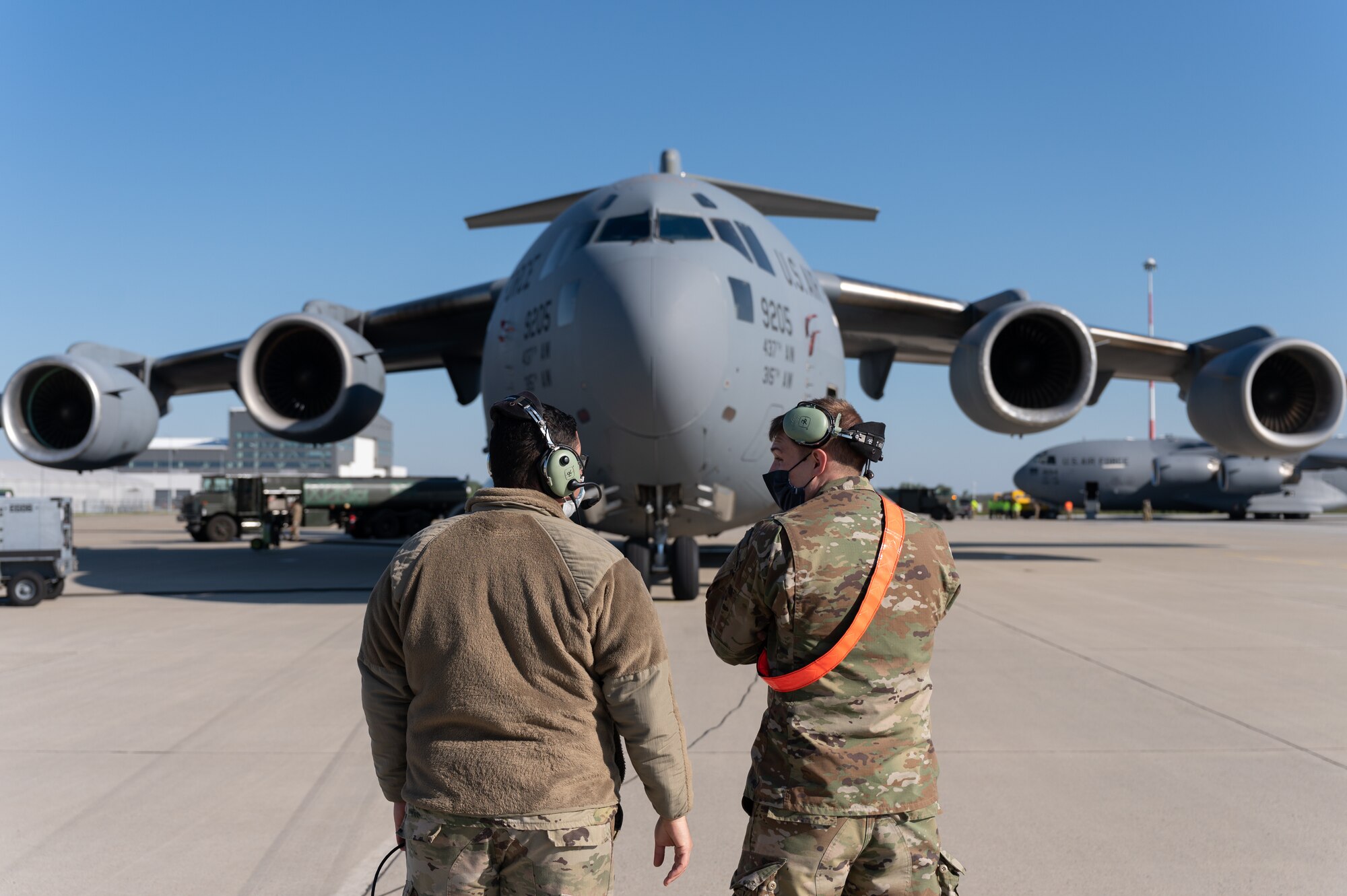 Two Airmen standing in front of an aircraft.
