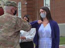 woman elbow bumps commanding general after receiving award