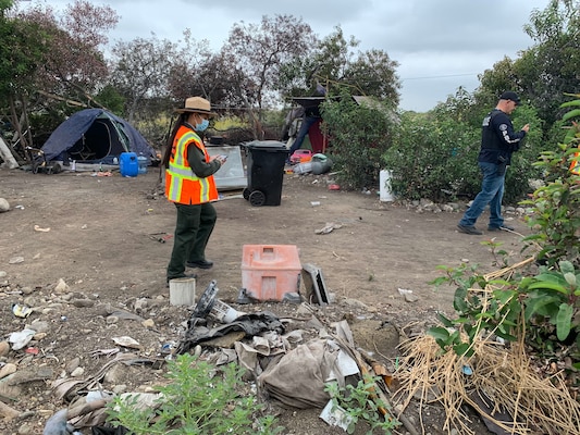 Park Ranger Annel Monsalvo, U.S. Army Corps of Engineers Los Angeles District, investigates one of dozens of abandoned campsites below the Santa Fe Dam, May 10, before crews arrive to clear out the debris.